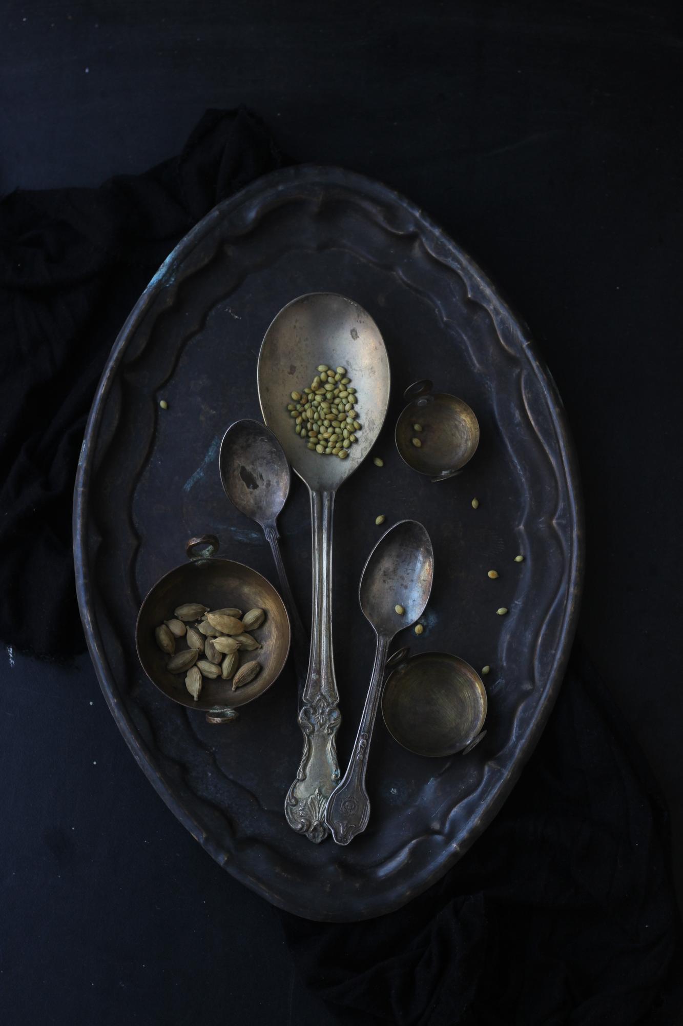 Plated tasting menu on dark slate with gold leaf