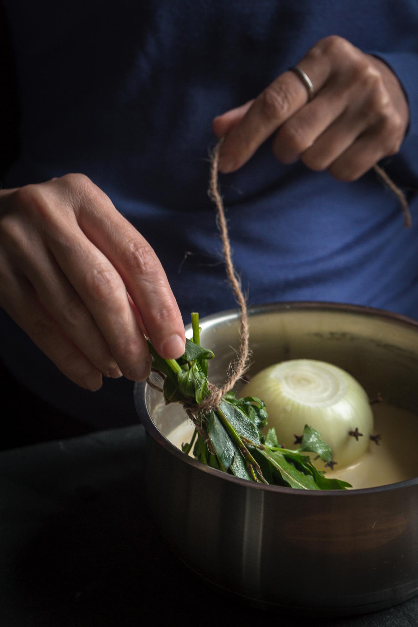 Chef arranging herbs on plate in studio